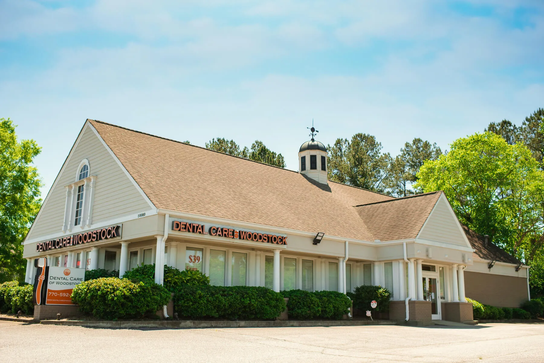 The Dental Care of Woodstock office on Highway 92, a cream-sided building with a cupola